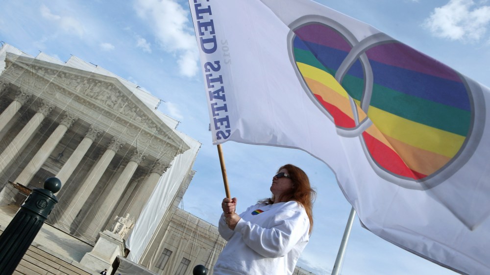 Same-sex marriage proponent Kat McGuckin of Oaklyn, New Jersey, holds a gay marriage pride flag while standing in front of the Supreme Court November 30, 2012 in Washington, DC (Photo by Chip Somodevilla/Getty Images)