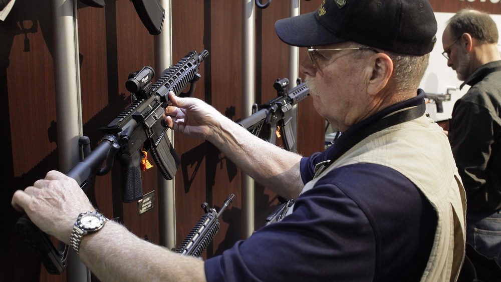An industry retailer examines various SIG SAUER sport rifles at the National Shooting Sports Foundation's Shooting, Hunting and Outdoor Trade show, Tuesday, Jan. 18, 2011 in Las Vegas. (AP/Julie Jacobson)