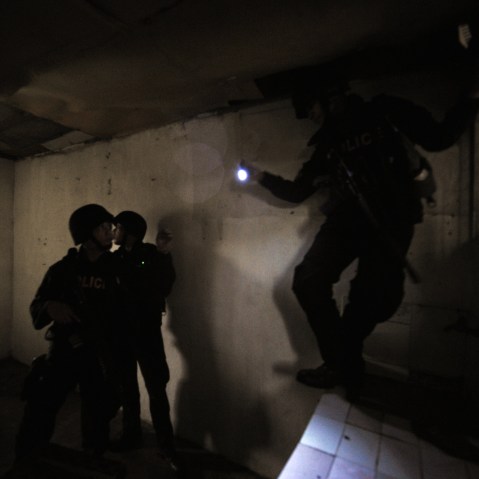 Members of SWAT team search a house for alleged gunmen.