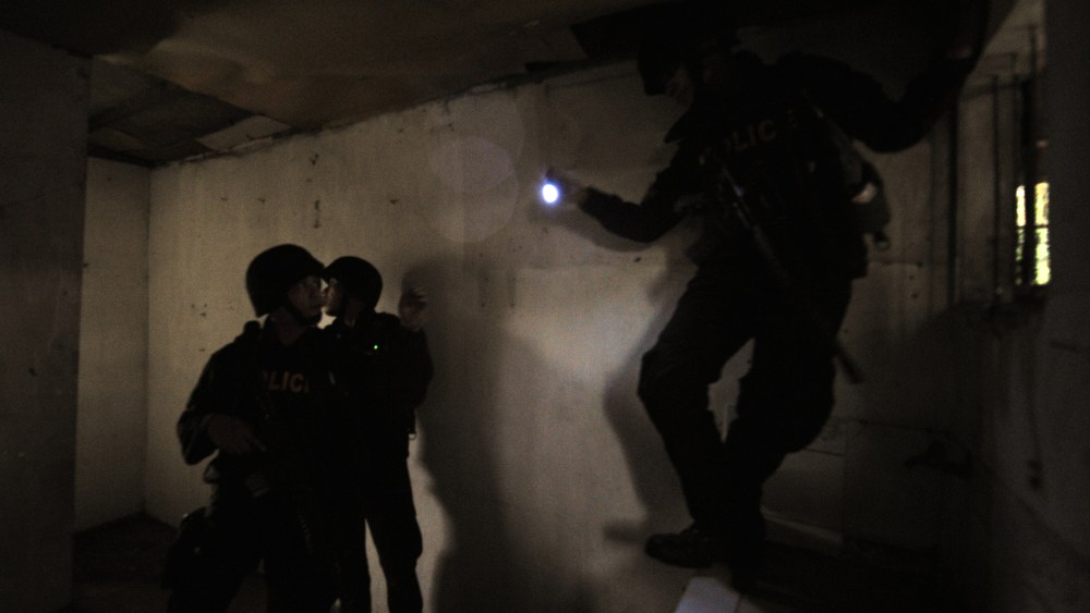Members of SWAT team search a house for alleged gunmen.