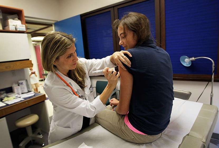 University of Miami pediatrician Judith L. Schaechter, M.D. (L) gives an HPV vaccination to a 13-year-old girl in her office at the Miller School of Medicine on September 21, 2011 in Miami, Florida. (Photo by Joe Raedle/Getty Images)