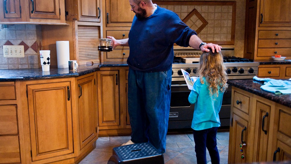 Keith Ohlinger, a stay at home dad and farmer in Maryland, pours a cup of coffee as his daughter Gabrielle, 4, asks him to read a story.