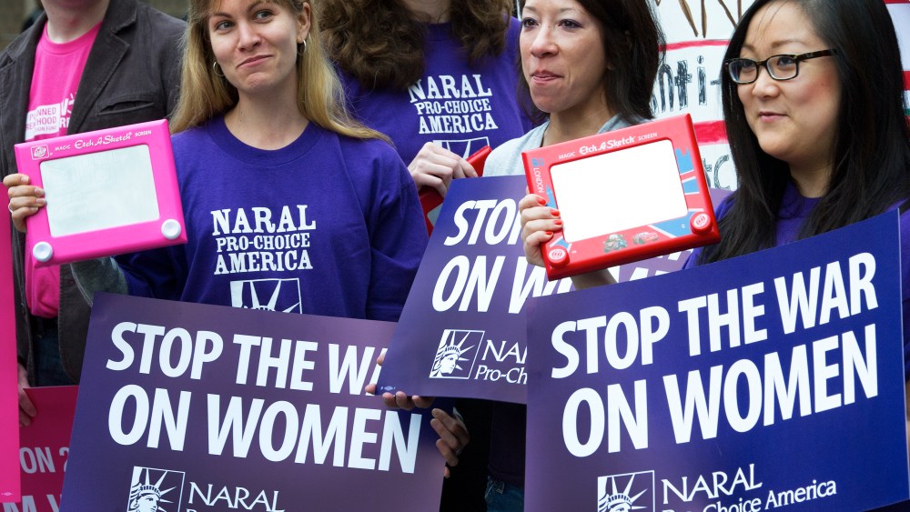A member of the National Abortion Rights Action League (NARAL), Pro-Choice America protest with their "Etch A Sketch" in hand protest outside a hotel in Washington, DC, on March 22, 2012. (Photo by Paul J. Richards/AFP/Getty)