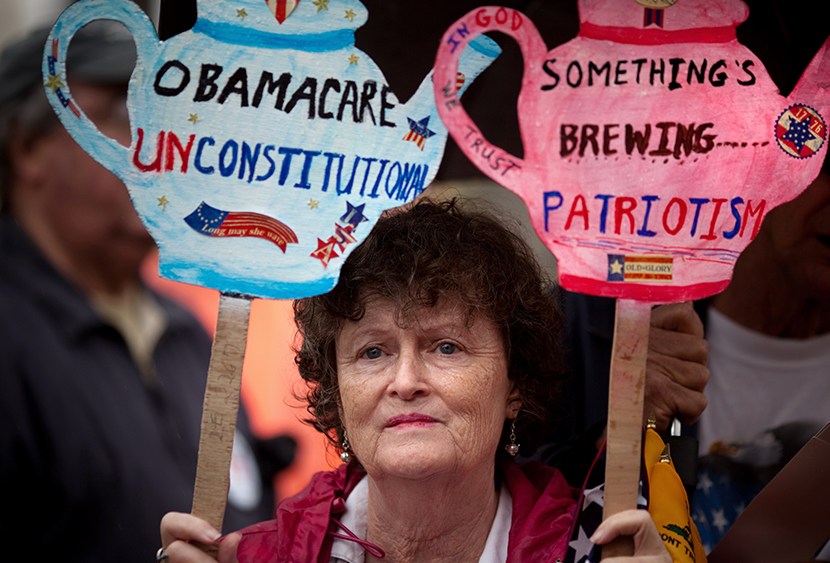 Carlene Cahill of Petersburg, Va., holds up a set of signs she made during a Tea Party Patriots' "Road To Repeal Rally" on a rainy day March 24, 2012,  in Washington, DC.  (Photo by Allison Shelley/Getty Images)