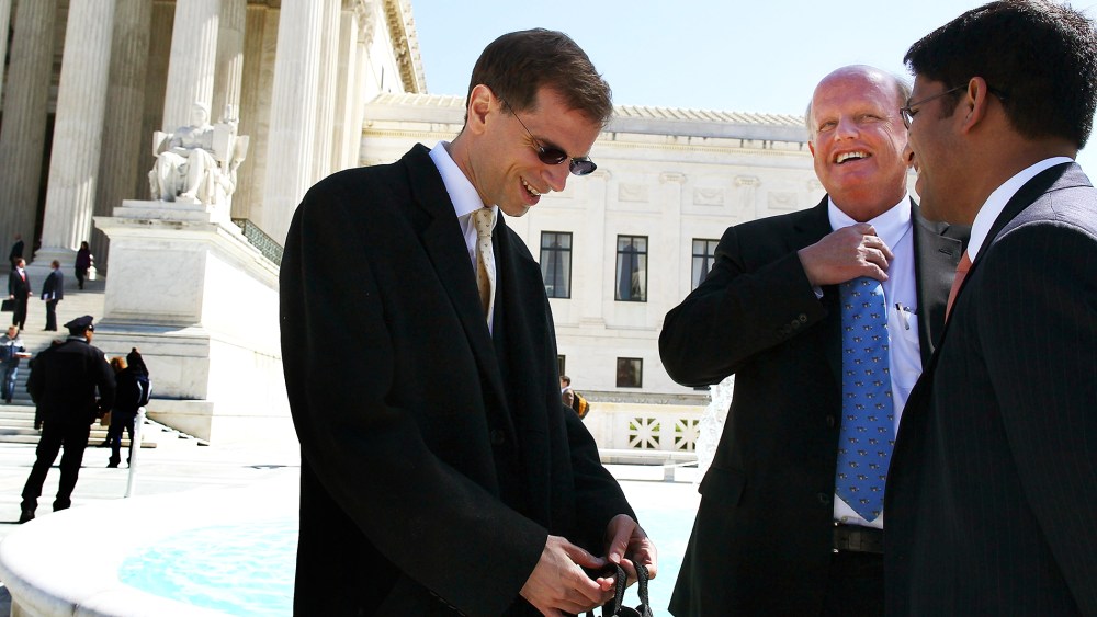 Attorney Michael A. Carvin (2R) stands outside the Supreme Court following the second day of oral arguments for the Affordable Care Act, Mar. 27, 2012.