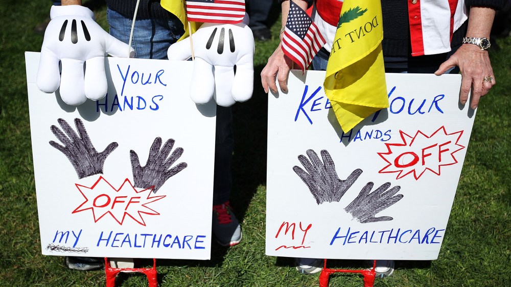 Tea Party supporters hold signs as they participate during a "Hands Off My Health Care" rally, March 27, 2012 on Capitol Hill in Washington, DC.