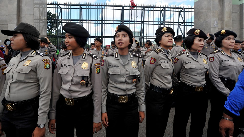 Indonesian policewomen stand guard while Indonesian workers of the All-Indonesia workers union (SPSI) hold a protest against the government's plan to hike fuel prices in Jakarta on March 29, 2012.