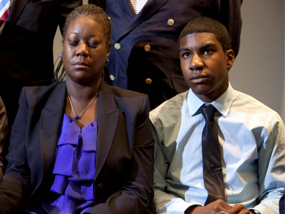 File Photo: The mother of Trayvon Martin, Sybrina Fulton (C) closes her eyes as she and  Trayvon's brother Jahvaris Fulton (R) watch a news conference on Wednesday, April 11, 2012, in Washington, DC as special prosecutor Angela Corey in Sanford,...