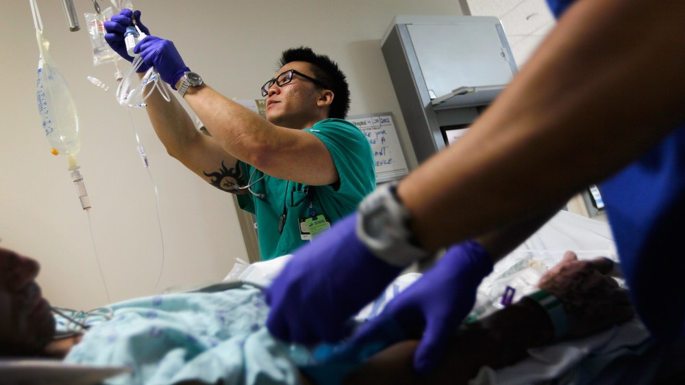 A nurse hangs an I.V. bag for a patient at the University of Miami Hospital, April 30, 2012.