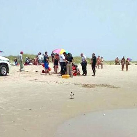 A man is treated on the beach after being attacked by a shark off Ocracoke Island in N.C. on July 1, 2015. (Photo by Jackson Fuqua)