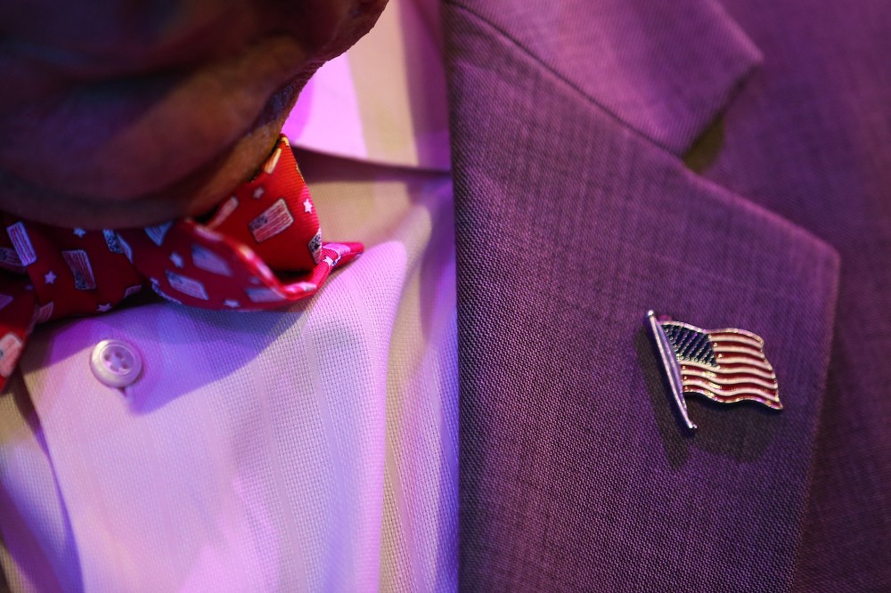 A man wears an American flag bowtie and lapel pin.