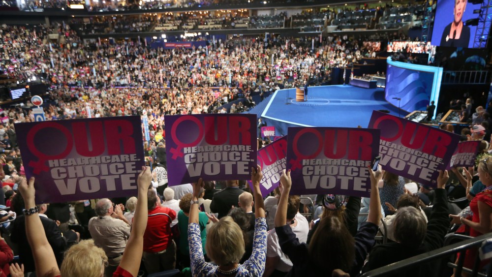 People hold signs as president of Planned Parenthood Federation of America, Cecile Richards, speaks during the Democratic National Convention on September 5, 2012 in Charlotte, North Carolina.