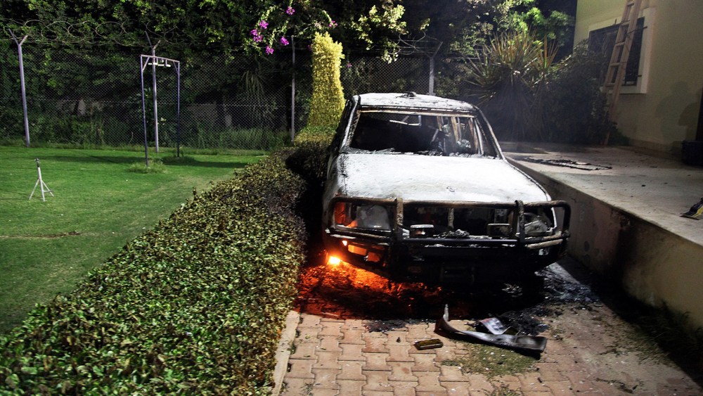 A burnt out vehicle sits smoldering in flames after it was set on fire inside the US consulate compound in Benghazi, Sept. 11, 2012.