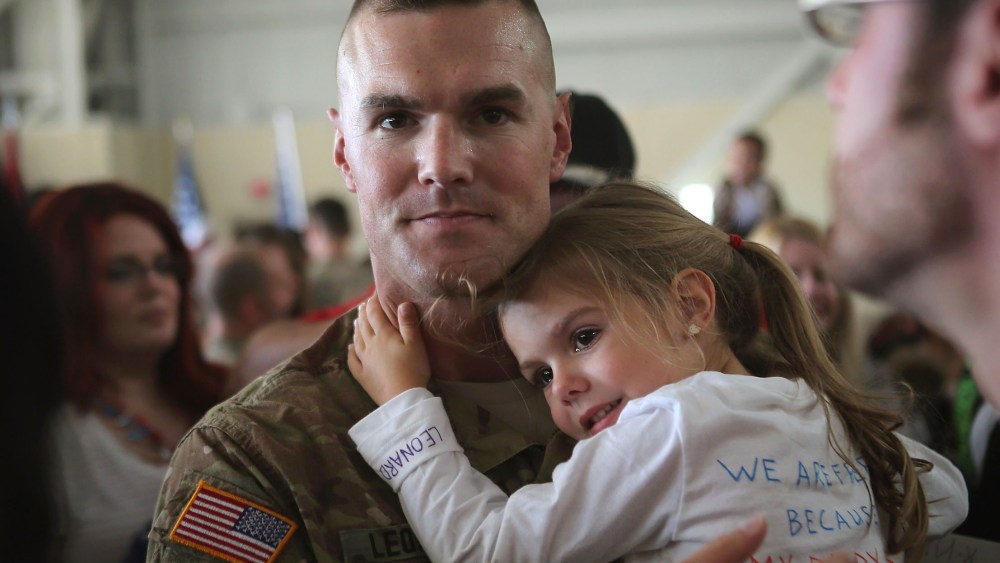 Haley Leonard holds on to her father SFC Kyle Leonard after he arrived at a homecoming ceremony with his unit, the 713th Engineer Company of the Indiana Army National Guard, at the Army Aviation Support Facility on September 26, 2012 in Gary, Indiana....