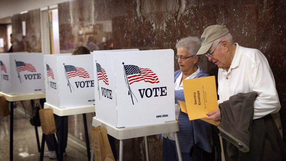 Betty Carlson (L) helps her husband Keith Carlson, who is visually impaired, fill out his ballot during early voting at the Black Hawk County Courthouse on September 27, 2012 in Waterloo, Iowa.