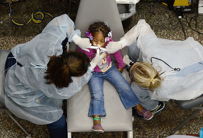 Kamora Cyprian, 2, gets her teeth cleaned as part of a free health care service for the uninsured at the Care Harbor clinic at the Los Angeles Sports Arena on September 27, 2012 in Los Angeles, California. (Photo by Kevork Djansezian/Getty Images)
