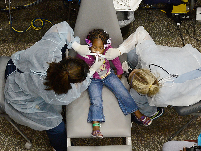 Kamora Cyprian, 2, gets her teeth cleaned as part of a free health care service for the uninsured at the Care Harbor clinic at the Los Angeles Sports Arena on September 27, 2012 in Los Angeles, California. (Photo by Kevork Djansezian/Getty Images)