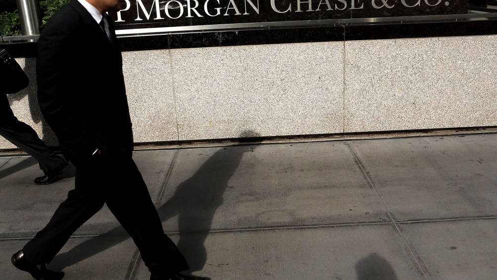 People pass a sign for JPMorgan Chase & Co. at it's headquarters in Manhattan on October 2, 2012 in New York City.