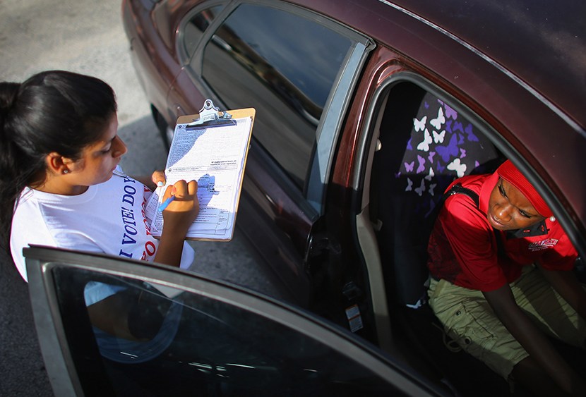 Karen Garcia (L) takes down Ruth Inalien's information as she signs her up to vote during a voter registration drive by members of the Florida Immigrant Coalition on October 4, 2012 in Pompano Beach, Florida. (Photo by Joe Raedle/Getty Images)