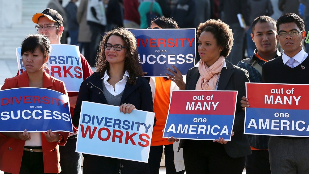 Protesters hold signs in front of the U.S. Supreme Court.