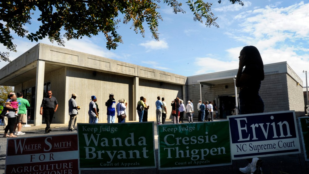 Campaign signs line the walk as people wait in line to vote in Wilson, North Carolina.