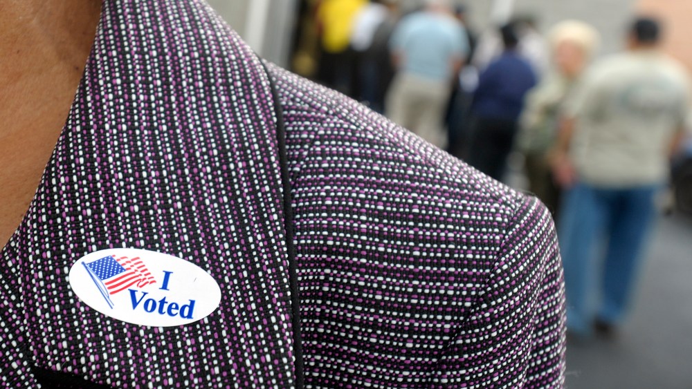File Photo: A voter displays their "I Voted" sticker on their lapel after voting as others wait in line for the first day of Early Voting on October 18, 2012 in Wilson, North Carolina. Early Voting is offered at select location from now through...
