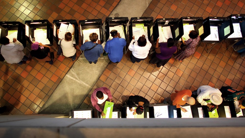 Early voters fill out their ballots as they cast their vote in the presidential election on the first day of early voting, on Oct. 27, 2012 in Miami, Fla.