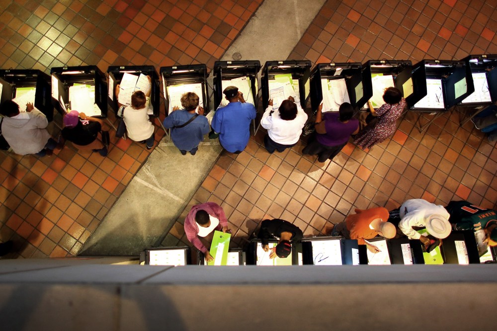 Early voters fill out their ballots as they cast their vote in the presidential election on the first day of early voting, on Oct. 27, 2012 in Miami, Fla.