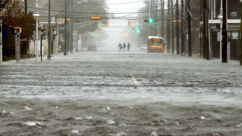 People walk down a flooded street as Hurricane Sandy moves up the coast on Oct. 29, 2012 in Atlantic City, N.J.