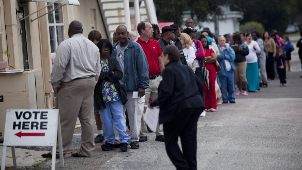 Lines of voters wait to cast their ballots as the polls open on November 6, 2012 in St. Petersburg, Florida.