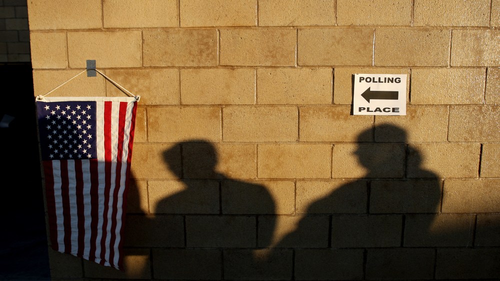 Voters cast shadows as they wait for their polling place in to open during the U.S. presidential election on Nov. 6, 2012 in the Los Angeles area community of Hermosa Beach, California.