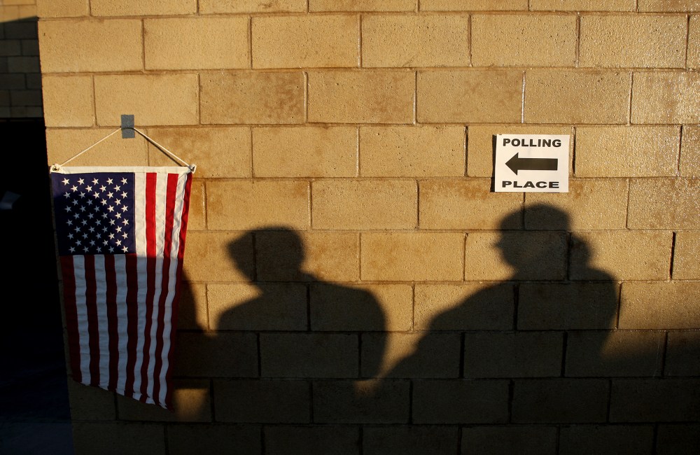 Voters cast shadows as they wait for their polling place in to open during the U.S. presidential election on Nov. 6, 2012 in the Los Angeles area community of Hermosa Beach, California.