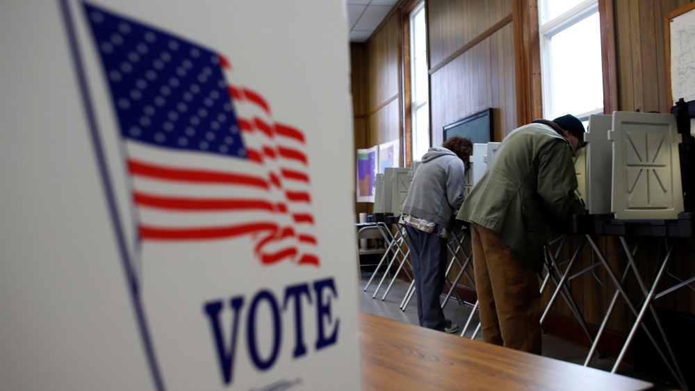 A man and woman cast their vote at a polling station on Nov. 6, 2012 in Sugar Creek, Wis.
