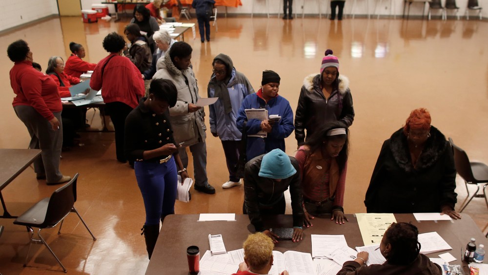 Voters wait in line to register before they can cast their ballots in the U.S. presidential election on Nov. 6, 2012 in Milwaukee, Wisc.