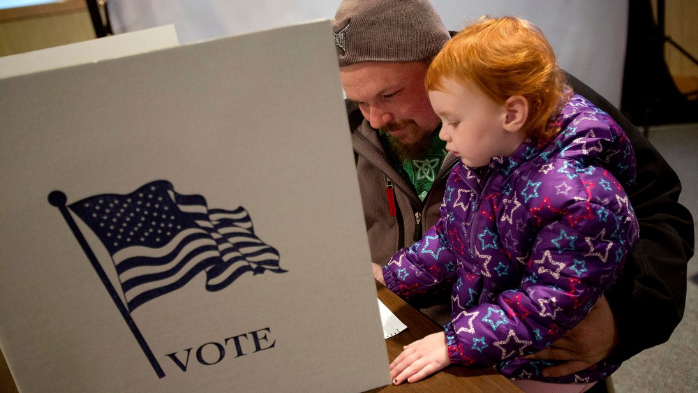 Dallas Seitz of Zwingle, Iowa fills out his ballot with his daughter, Madeline, 3, at the Saint Lawrence Church on November 6, 2012 in Otter Creek, Iowa.