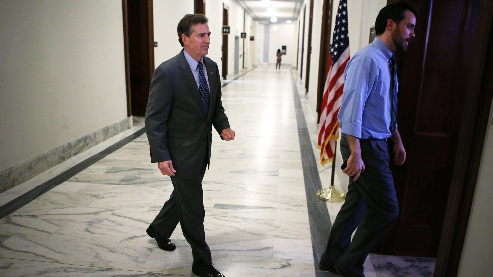 U.S. Senator Jim DeMint enters his office with his communications director Wesley Denton December 6, 2012 on Capitol Hill in Washington, DC.