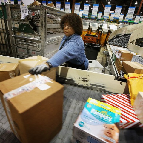 Bobbi Crump moves mail on a conveyor, December 17, 2012 in Elk Grove Village, Illinois.