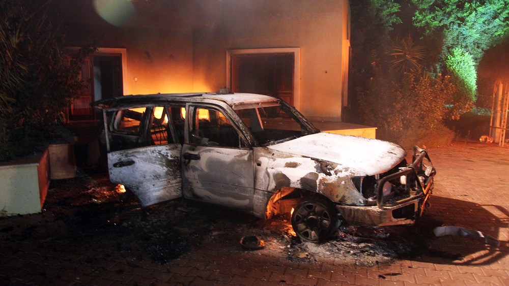 A vehicle and surrounding buildings smolder after they were set on fire inside the US mission compound in Benghazi., Sept. 11, 2012.