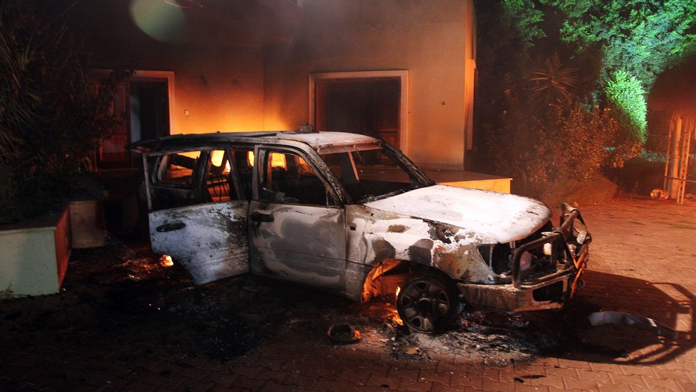 A vehicle and surrounding buildings smoldering after they were set on fire inside the US mission compound in Benghazi, September 11, 2012.