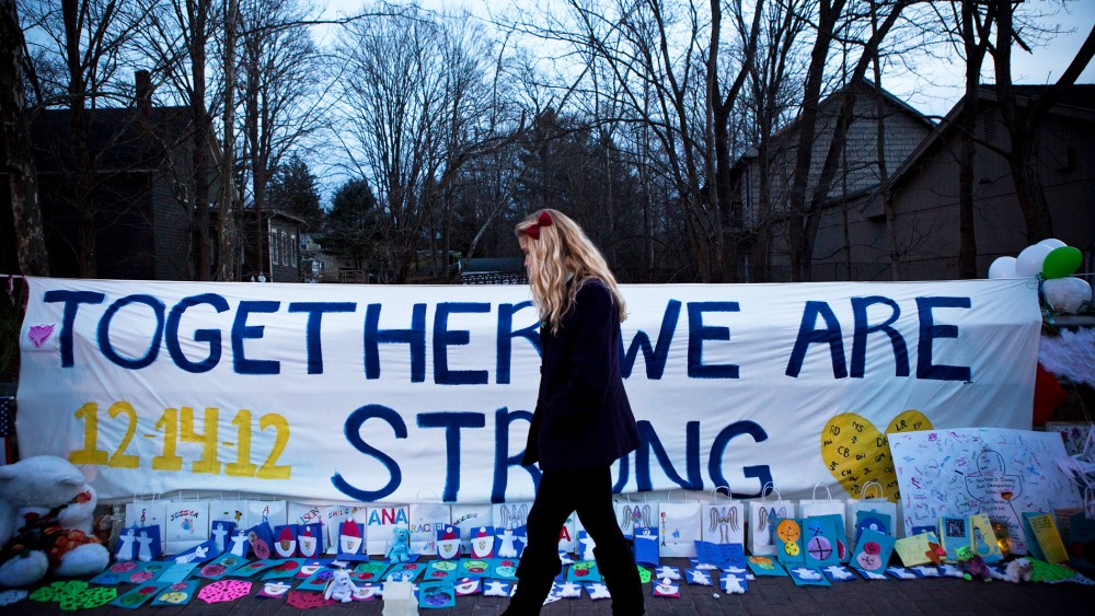 A woman walks past a memorial for those killed in the school shooting at Sandy Hook Elementary School on December 24, 2012.