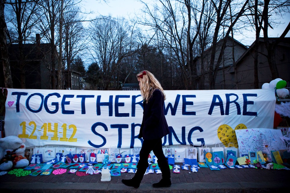 A woman walks past a memorial for those killed in the school shooting at Sandy Hook Elementary School on December 24, 2012.