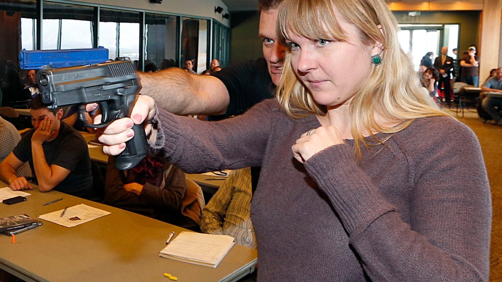 Joanna Baginska (R), a fourth grade teacher at Odyssey Charter School in American Fork, Utah is shown how to handle a 40 cal. Sig Sauer by firearm instructor Clark Aposhian at a concealed-weapons training class to 200 Utah teachers on December 27, 2012...