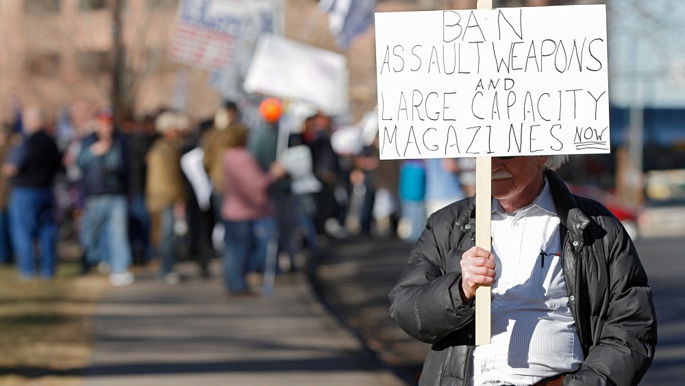 A lone anti-gun activist protests as Second Amendment demonstrators rally on Jan. 9, 2013 at the Colorado State Capitol in Denver, Colo. (Photo by Marc Piscotty/Getty)