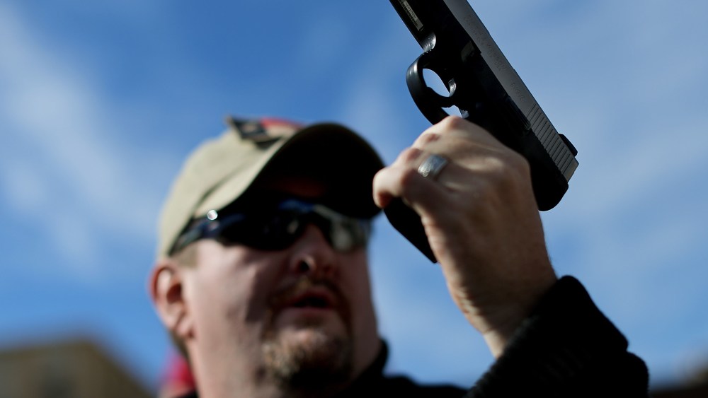 Second Amendment supporter and gun enthusiast Derek Ringley displays an unloaded pistol that was being sold in an impromptu auction across the street from a gun buy back program at the First Presbyterian Church of Dallas on January 19, 2013 in Dallas,...