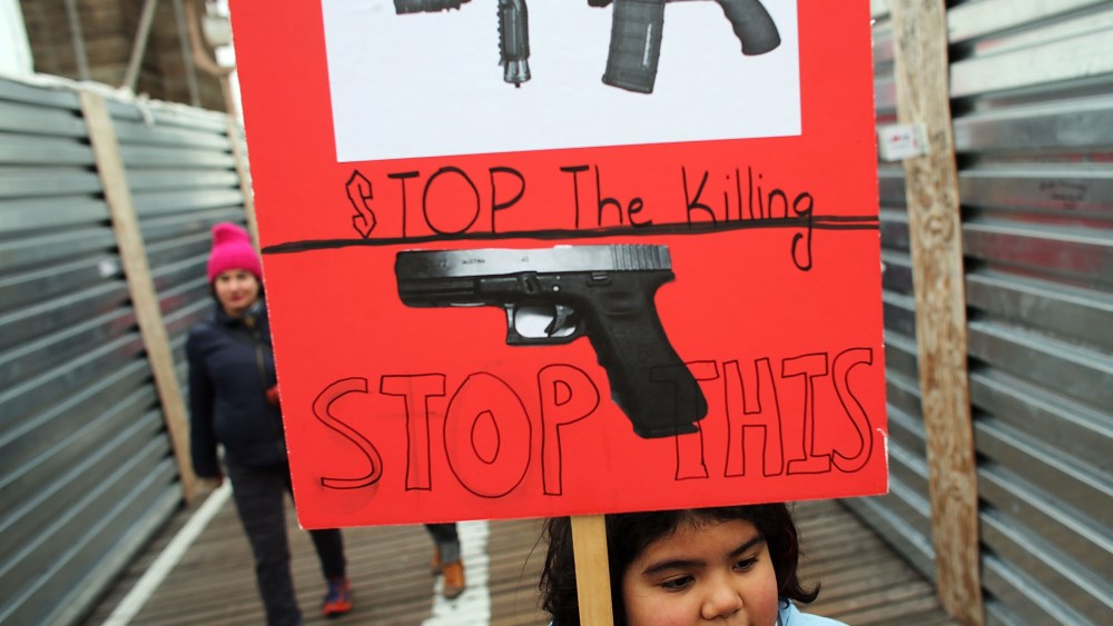 Luna Miller holds a anti gun sign while participating in a rally and march across the Brooklyn Bridge with One Million Moms for Gun Control, a gun control group formed in the wake of last month's massacre at a Newtown, Connecticut elementary school on...