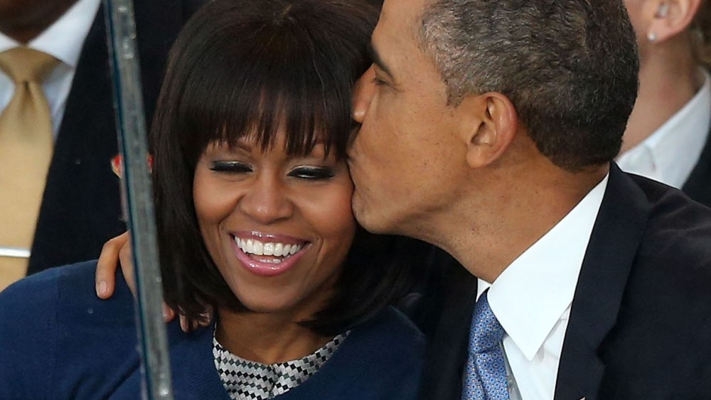 U.S. President Barack Obama (R) kisses first lady Michelle Obama on the reviewing stand as the presidential inaugural parade winds through the nation's capital January 21, 2013 in Washington, DC. Barack Obama was ceremonially sworn in for a second term...