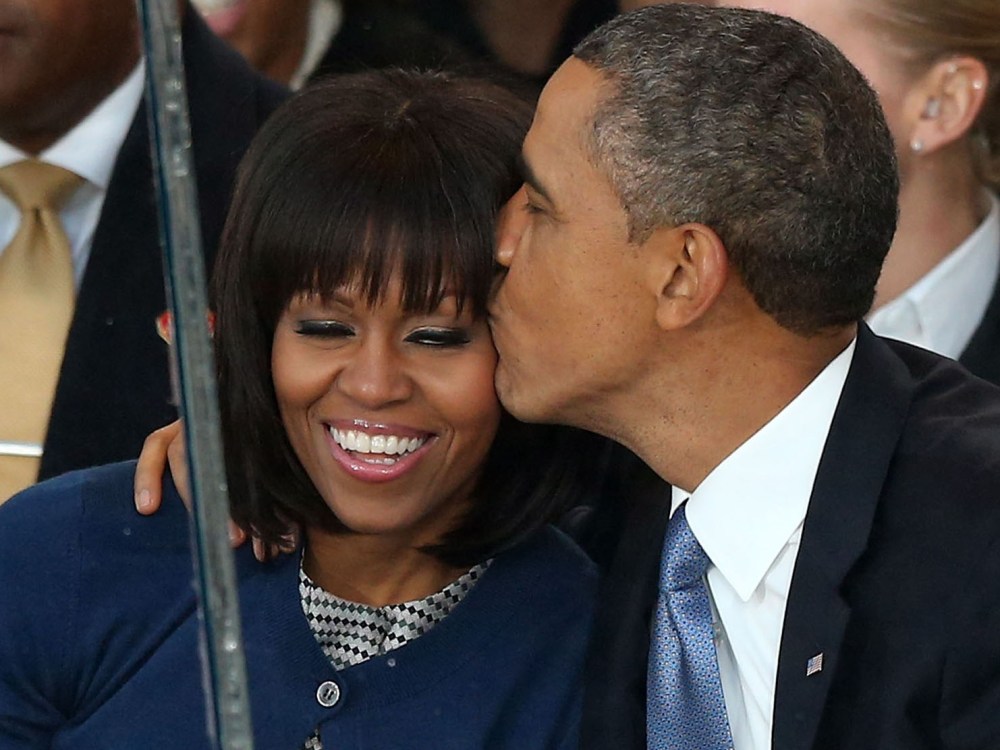 U.S. President Barack Obama (R) kisses first lady Michelle Obama on the reviewing stand as the presidential inaugural parade winds through the nation's capital January 21, 2013 in Washington, DC. Barack Obama was ceremonially sworn in for a second term...