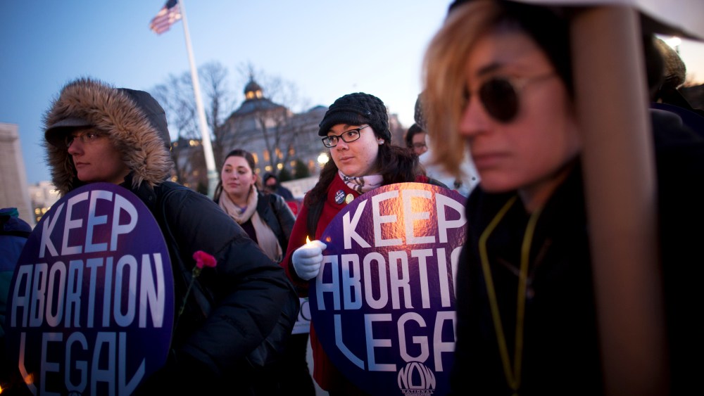 Attendees listen during a candlelight vigil organized by the National Organization for Women in front of the U.S. Supreme Court, Jan. 22, 2013.