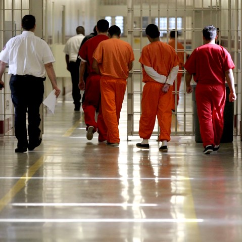 Detainees at the Stewart Detention Center in Lumpkin, Ga. are escorted through a corridor. (Photo by Jonathan Wiggs/The Boston Globe via Getty)