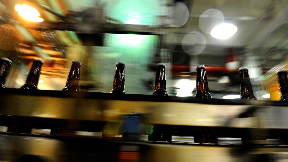 Bottles speed by after being filled in the bottling area of the Coors brewery in Golden, Colo.